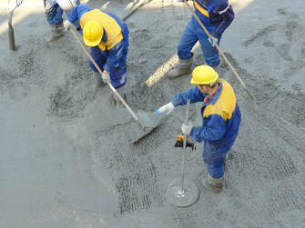 workers in the midst of fresh concrete cement